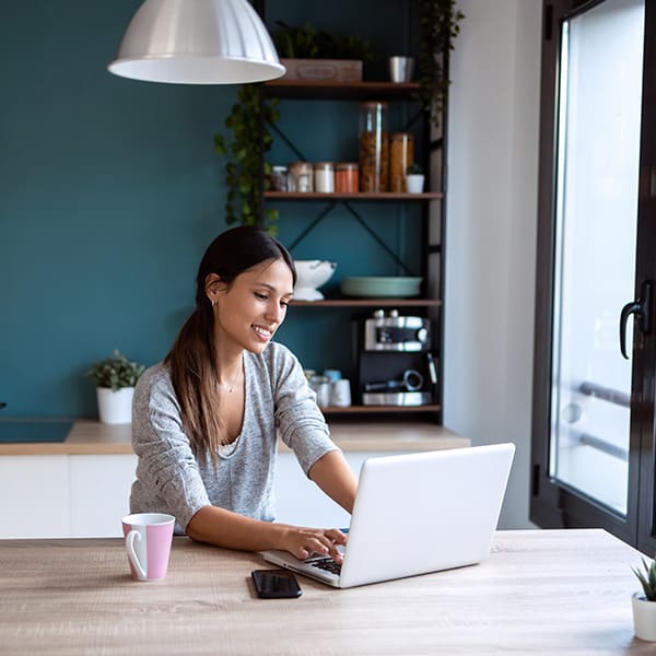 Woman on her laptop in her kitchen learning about the steps to solve low keyword ranking