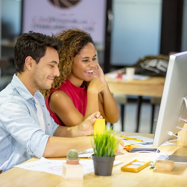 Couple at computer learning how to install WordPress on GoDaddy